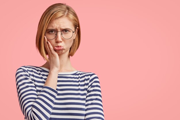 Giovane donna bionda in camicia a righe