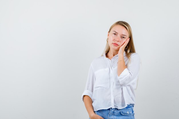 Giovane donna bionda in camicia bianca