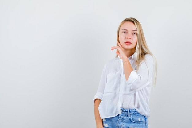 Giovane donna bionda in camicia bianca