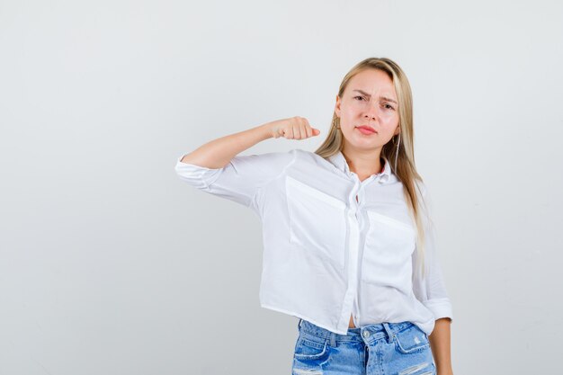 Giovane donna bionda in camicia bianca