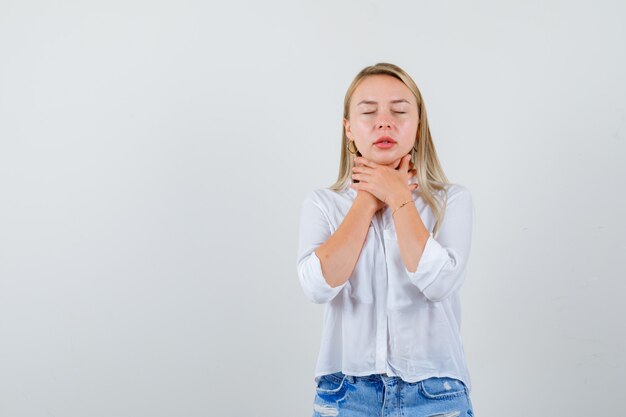 Giovane donna bionda in camicia bianca