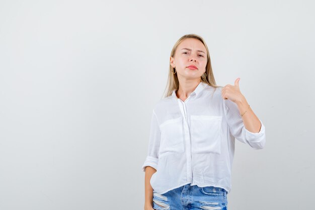 Giovane donna bionda in camicia bianca