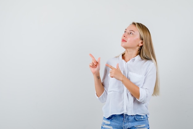 Giovane donna bionda in camicia bianca