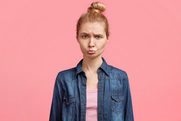 Giovane donna bionda in camicia di jeans