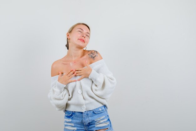 Giovane donna bionda in un cardigan bianco