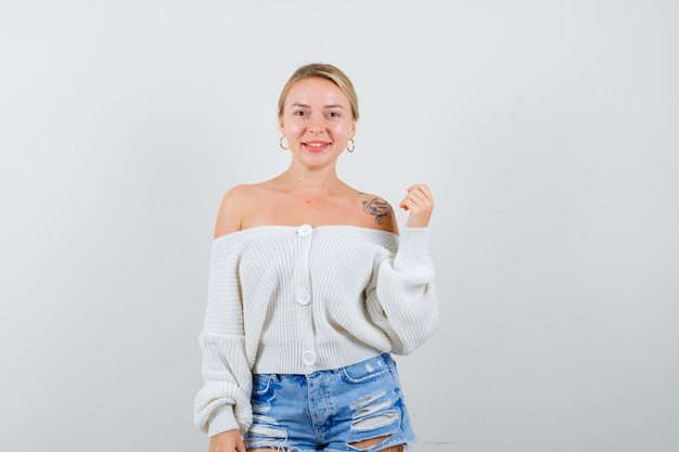 Giovane donna bionda in un cardigan bianco