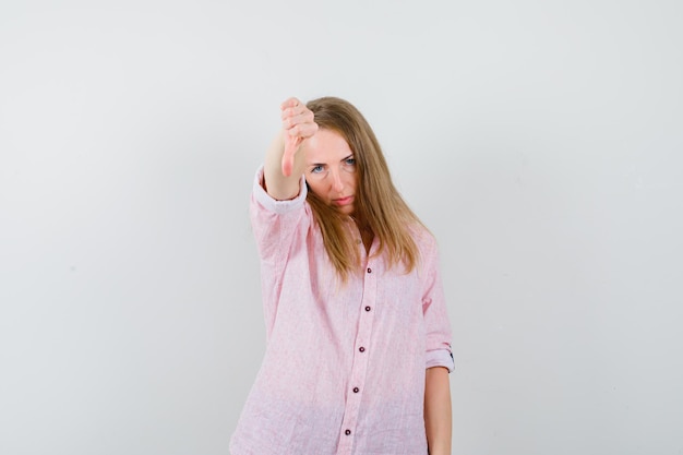 Giovane donna bionda in una camicia rosa casual