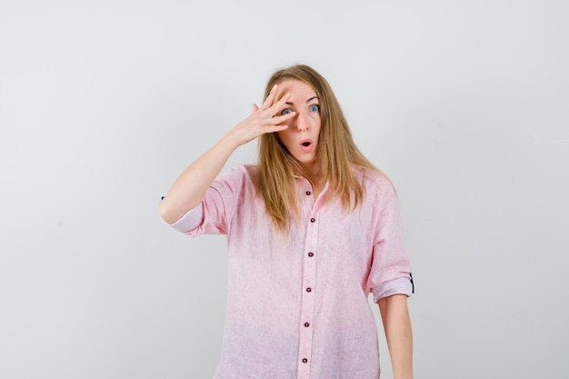 Giovane donna bionda in una camicia rosa casual