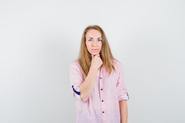 Giovane donna bionda in una camicia rosa casual