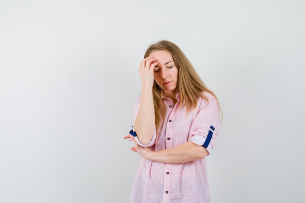 Giovane donna bionda in una camicia rosa casual