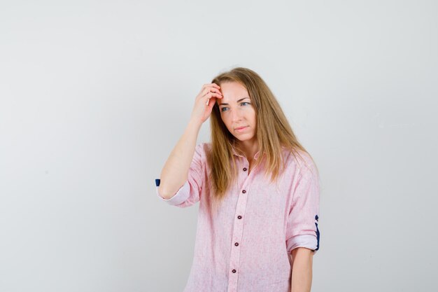 Giovane donna bionda in una camicia rosa casual