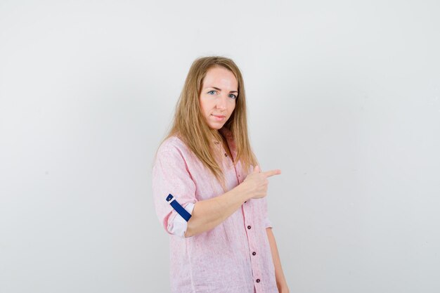 Giovane donna bionda in una camicia rosa casual