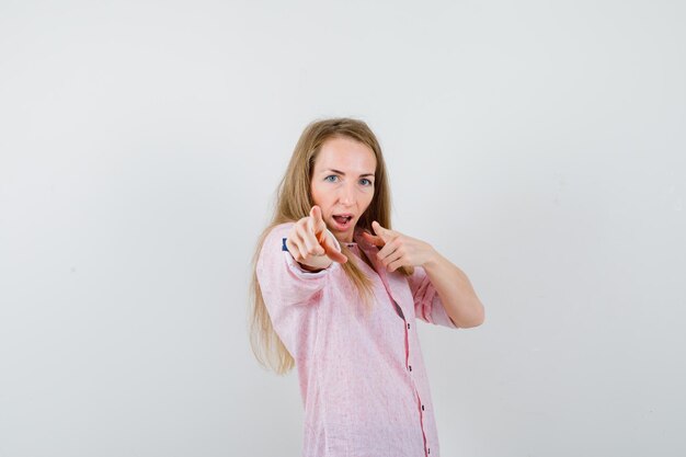 Giovane donna bionda in una camicia rosa casual