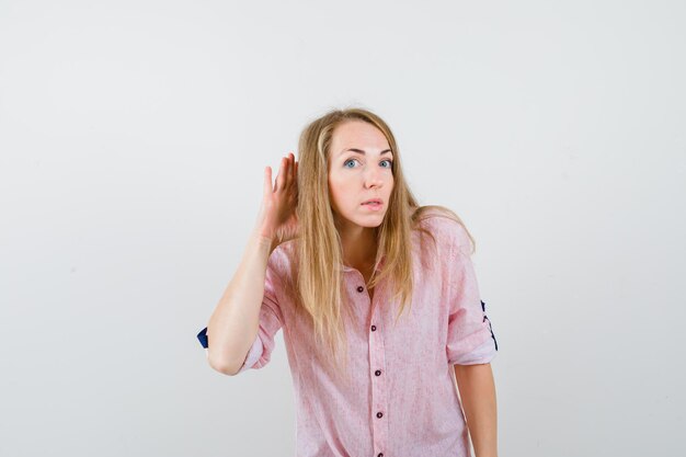 Giovane donna bionda in una camicia rosa casual