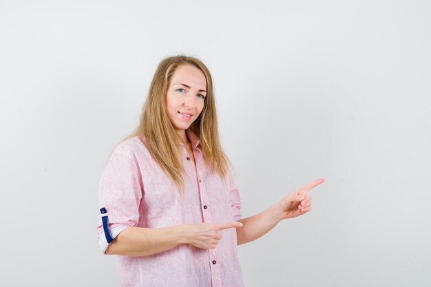 Giovane donna bionda in una camicia rosa casual