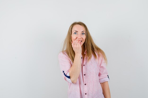 Giovane donna bionda in una camicia rosa casual