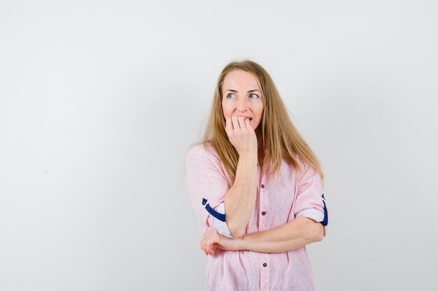 Giovane donna bionda in una camicia rosa casual