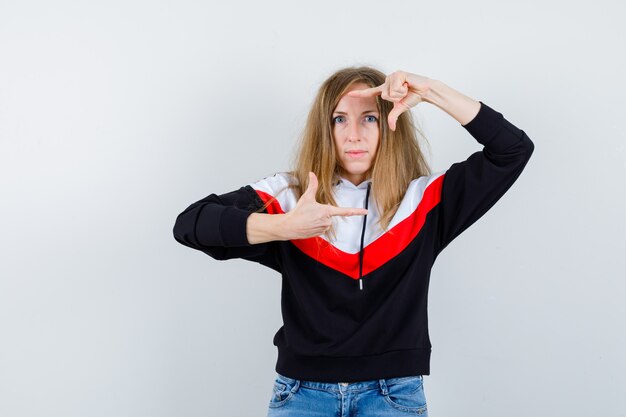 Giovane donna bionda in una giacca e jeans