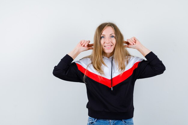 Giovane donna bionda in una giacca e jeans