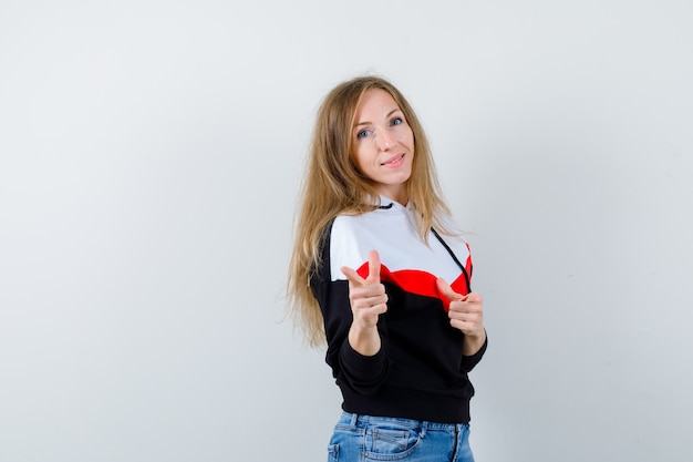 Giovane donna bionda in una giacca e jeans