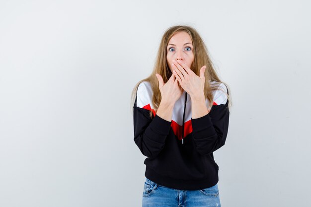 Giovane donna bionda in una giacca e jeans