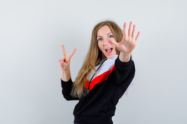 Giovane donna bionda in una giacca e jeans