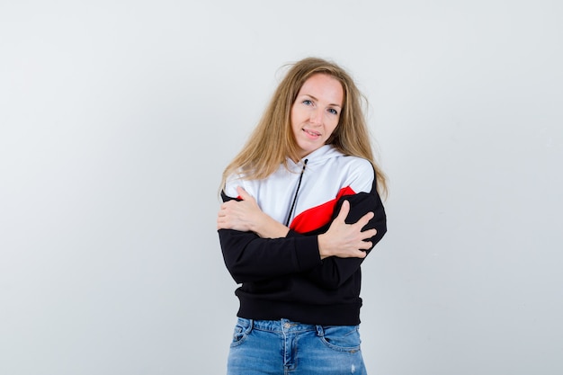 Giovane donna bionda in una giacca e jeans