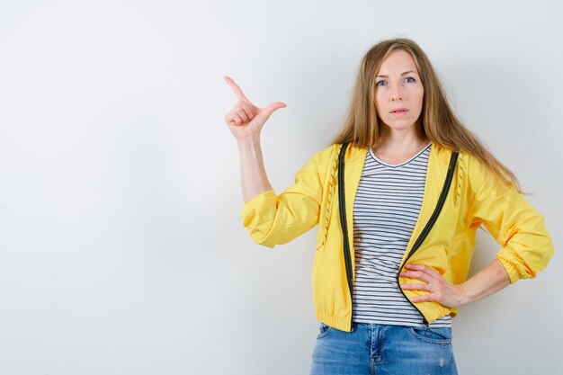 Giovane donna bionda in una giacca gialla