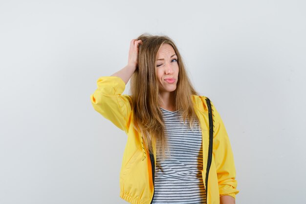 Giovane donna bionda in una giacca gialla