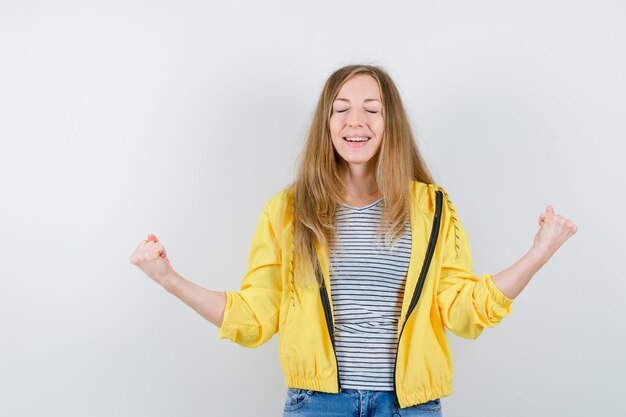 Giovane donna bionda in una giacca gialla