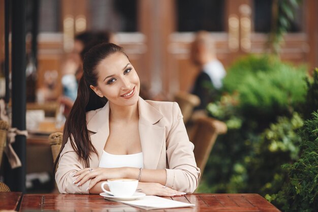 giovane donna carina nella terrazza del caffè all'aperto