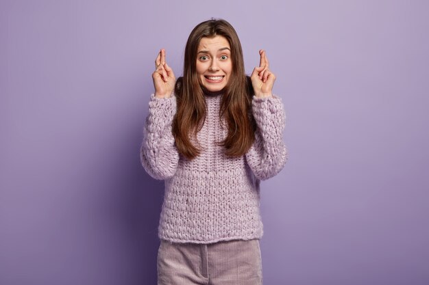 Giovane donna castana che indossa un maglione viola