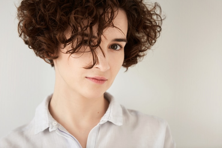 Foto gratuito giovane donna castana con capelli ricci