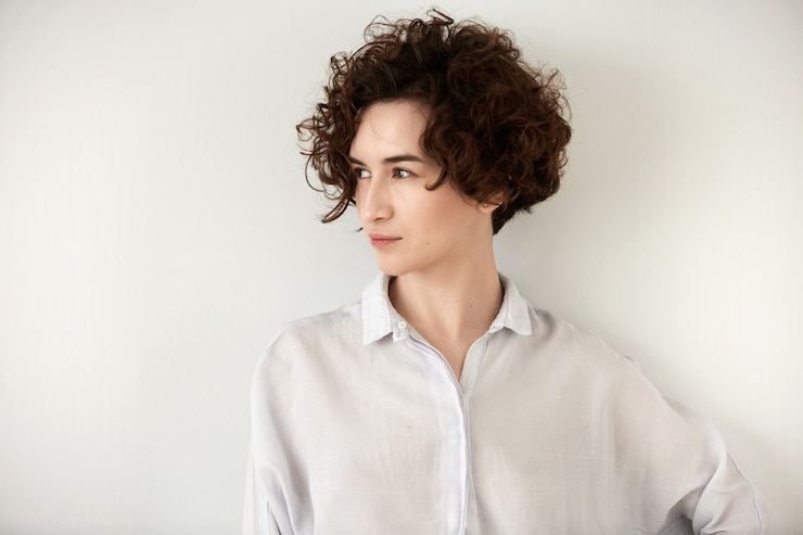 Foto gratuito giovane donna castana con capelli ricci