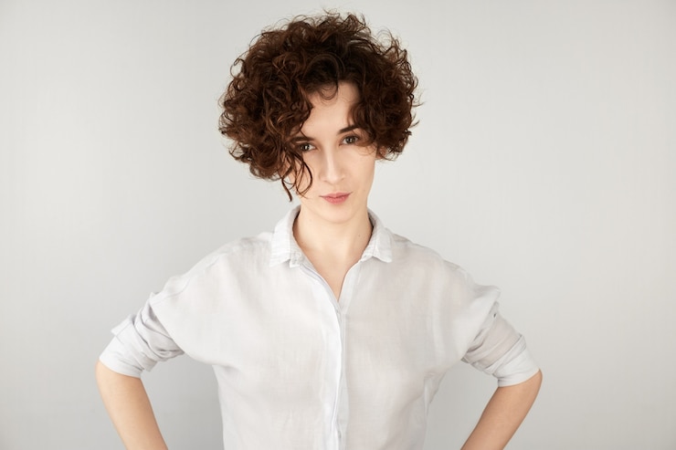 Foto gratuito giovane donna castana con capelli ricci