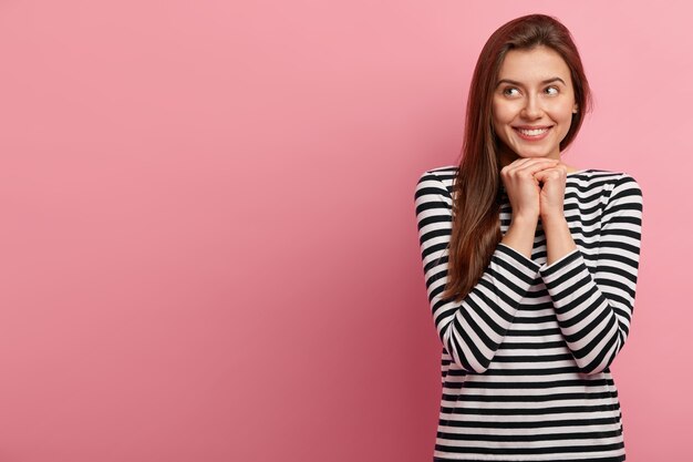 Giovane donna castana in camicia a righe