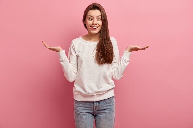 Giovane donna castana in jeans e maglione