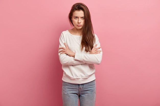 Giovane donna castana in jeans e maglione