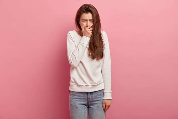 Giovane donna castana in jeans e maglione