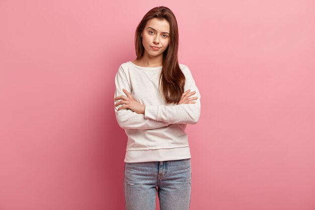 Giovane donna castana in jeans e maglione