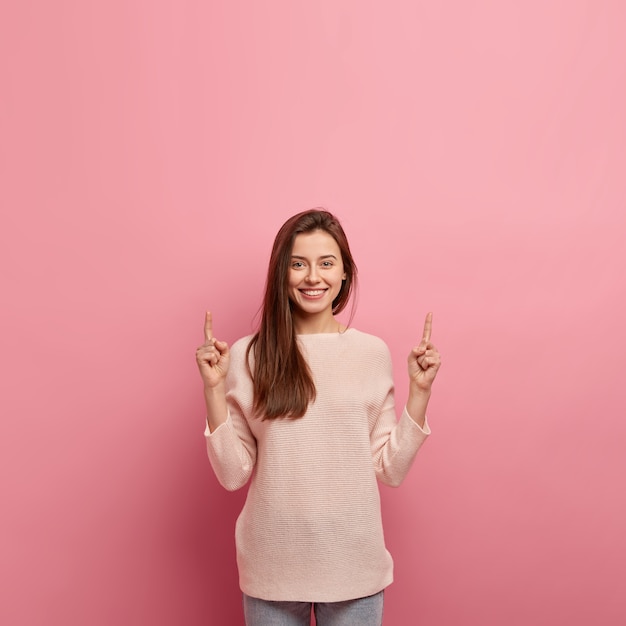 Giovane donna castana in jeans e maglione