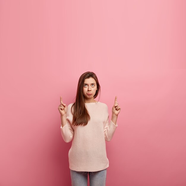 Giovane donna castana in jeans e maglione