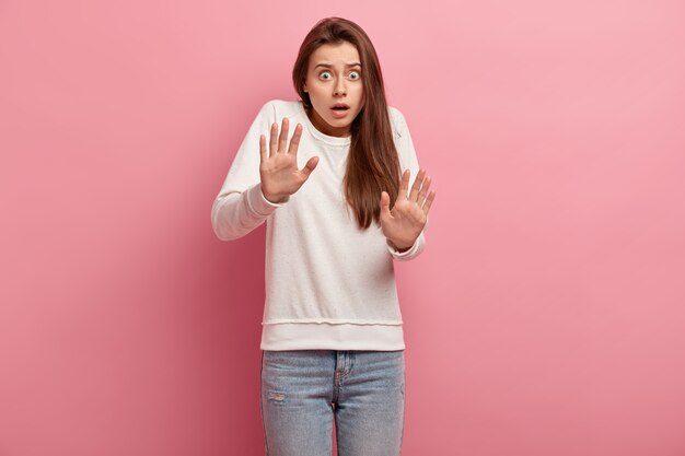 Giovane donna castana in jeans e maglione