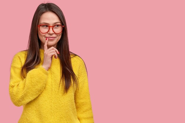 Giovane donna castana in maglione giallo