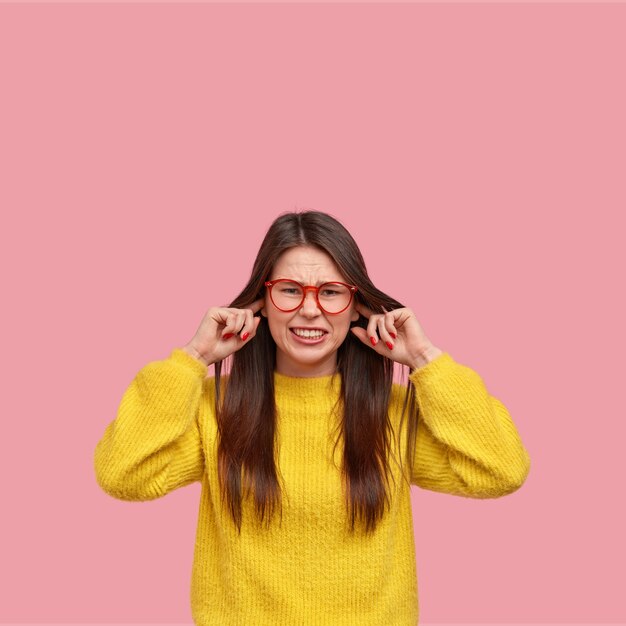 Giovane donna castana in maglione giallo