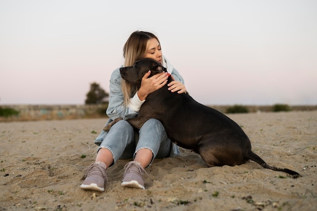 Giovane donna che abbraccia il suo pitbull