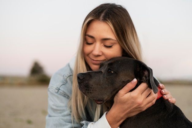 Giovane donna che abbraccia il suo pitbull