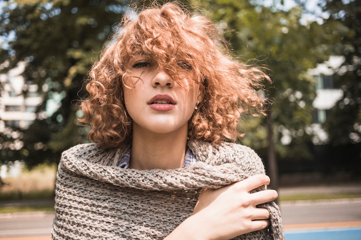Foto gratuito giovane donna che avvolge in sciarpa nel parco
