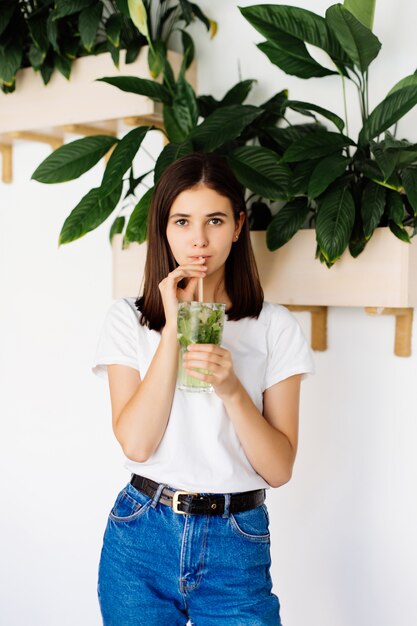 Giovane donna che beve bevanda fresca in caffè