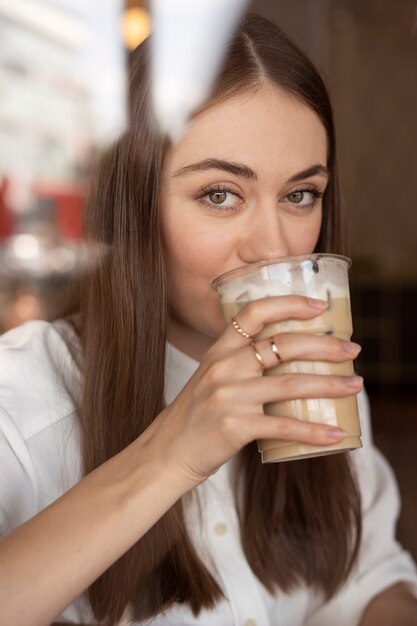 Giovane donna che beve caffè freddo